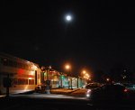 Its a full moon as a eastbound train rolls to a scheduled stop
